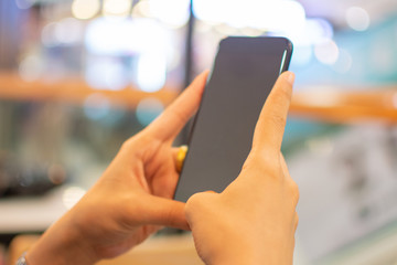 woman's hand holding smart phone with blur background. selective focus and soft focus.