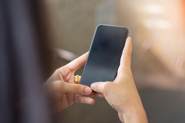 woman's hand holding smart phone with blur background. selective focus and soft focus.