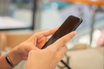 woman's hand holding smart phone with blur background. selective focus and soft focus.