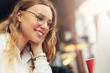 Woman Wear Glasses, Drink Her Hot Coffee While Work In Cafe On Her Laptop. Portrait Of Stylish Smiling Woman In Winter Clothes Drinking Hot Coffee And Work At Laptop. Female Winter Style. - Image