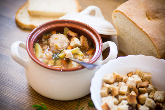 vegetable soup with beans and meatballs in a ceramic bowl