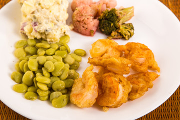 Shrimp battered in tempura sauce and deep fried with beans and potato salad