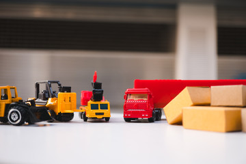 Fototapeta premium Construction vehicles and cardboard boxes using as logistics concept