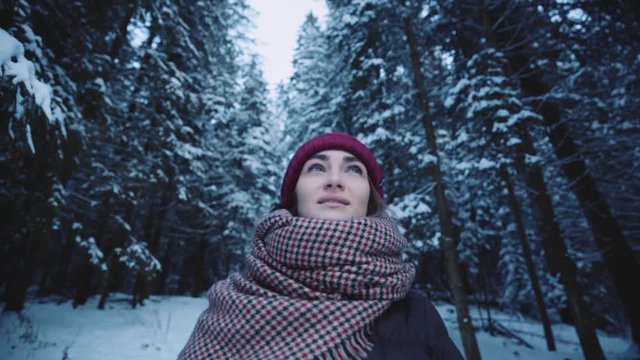 Smiling stylish young beautiful woman stand in winter forest look around cold snow girl happy nature white holiday outdoor park pretty attractive fashion fun happiness model slow motion