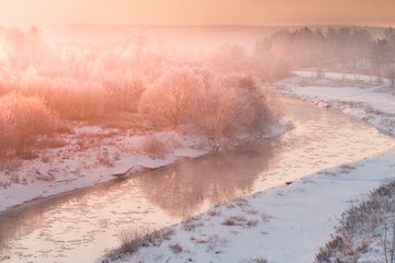 Fototapeta premium winter panorama landscape with forest, trees covered snow and sunrise. winterly morning of a new day. red winter landscape with river snow and forest