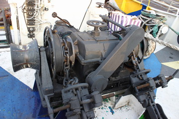 Old gray ship anchor winch on vessel deck