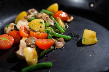 steamed vegetables on a black plate