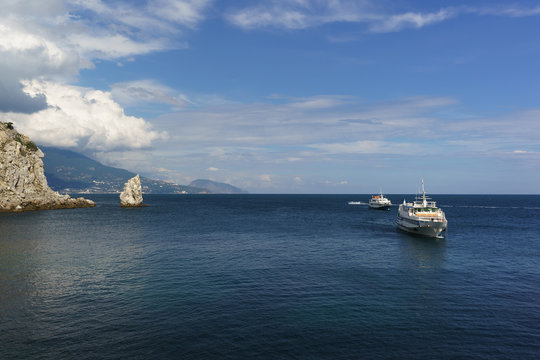 Fototapeta Two white ships sail the calm blue sea on a Sunny day. Cape Limen-Burun and rock Sail in the black sea resort of Crimea
