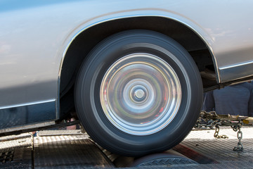 A car running at full speed on a dynamometer. The car is not moving but the wheel is spinning full...