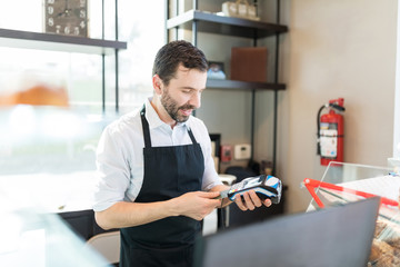 Salesman Using Credit Card Reader In Store