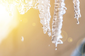 spring season begin, sunny sky and icicles hang from roof ledge and melting f