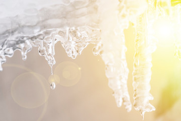 spring season begin, sunny sky and icicles hang from roof ledge and melting f