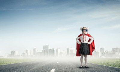 Fototapeta premium Girl power concept with cute kid guardian against cityscape back