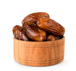 Dates in wooden plate close up on a white. Isolated.