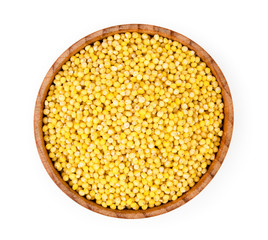 Millet in wooden plate close-up on a white. The view from the top.