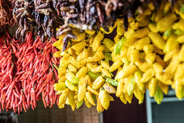 Central market: a variety of dried pepper varieties in bundles above the counter.  Selective focus.