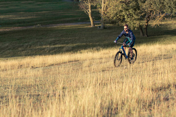 Cyclist in shorts and jersey on a modern carbon hardtail bike with an air suspension fork	