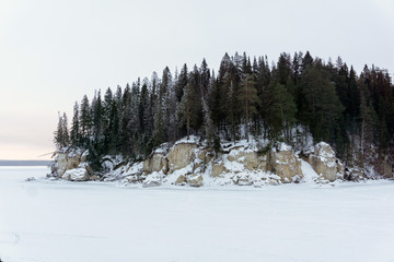 winter landscape with a rocky island on a frozen river