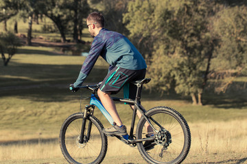Fototapeta premium Cyclist in shorts and jersey on a modern carbon hardtail bike with an air suspension fork 