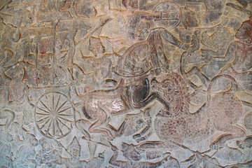 12th century carved wall, depicting a warrior on horseback at Angkor wat showing signs of damage from the touch of many tourists
