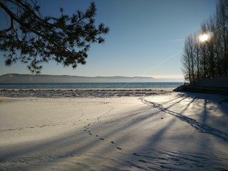 Winter sunny beach overlooking the foggy mountains 