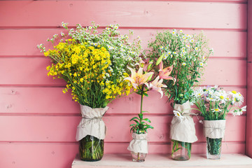 Fototapeta na wymiar Home decor. Wildflowers in a vase on a background of wooden pink boards. 