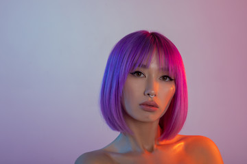 Woman in colorful bright lights posing in studio.