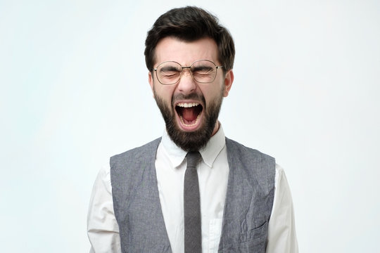 Angry spanish business man with beard screaming. Negative facial emotion.