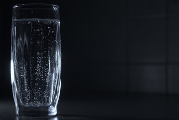 a glass of soda water on a dark background