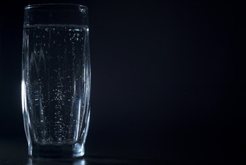a glass of soda water on a dark background