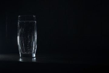 a glass of soda water on a dark background