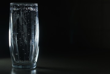 a glass of soda water on a dark background