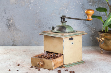 Old coffee grinder on concrete background.