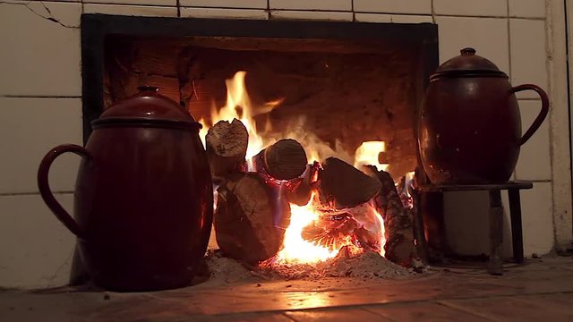 Pucheros al fuego del hogar en el interior de casa rural