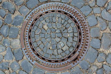 Fototapeta na wymiar Top view of the sewer manhole with paving stone background.