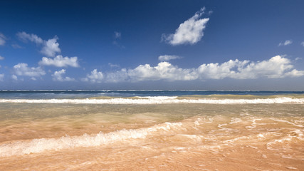 Soft Wave Of Blue Ocean On Sandy Beach. Background. Splash of waves on the sandy beach. foam, surf, waves