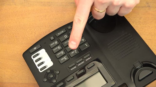 dialing a telephone number using telephone buttons.
