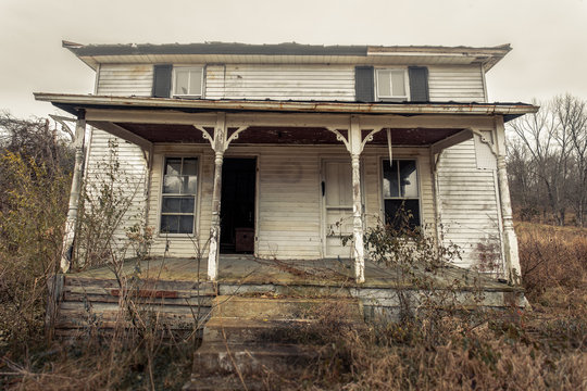 Close Up Of Abandoned Farm House With Porch And Awning