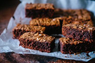 Cutting brownie pieces, homemade baking. Brownie in nut paste on on baking paper. close-up
