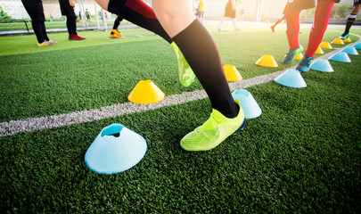 Soccer player Jogging and jump between cone markers on green artificial turf
