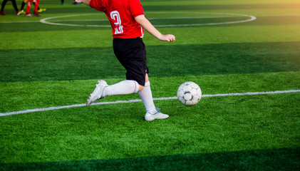 Soccer player speed run to shoot ball to goal on artificial turf