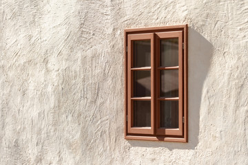 Fototapeta na wymiar A traditional wooden window set into a rendered house exterior.