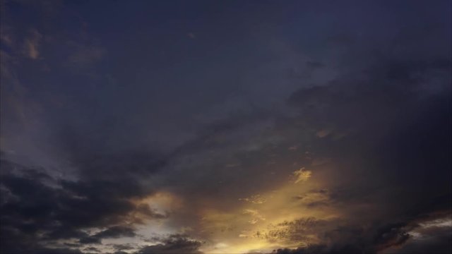 yellow dark sunset sky and clouds timelapse motion video of fast flying, passing, moving, rolling cloudscape, day to night bright colors nature background.