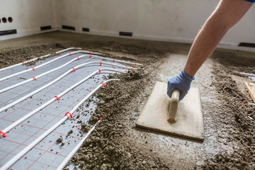 Screed flooring. Worker at a construction site screed floor.