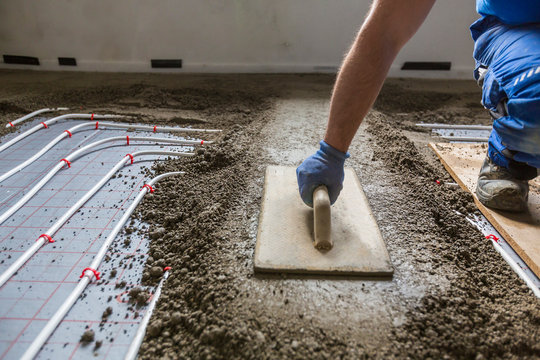 Screed Flooring. Worker At A Construction Site Screed Floor.