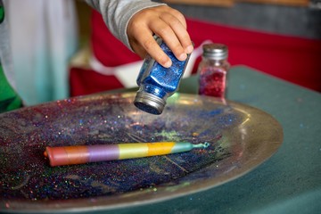sprinkling glitter over candle