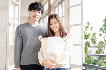 young asian couple holding laundry basket © taka