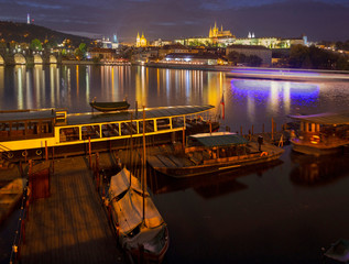Prague - Charles bridge, castle and cathedral with the little harbor at dusk.