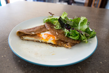 Filled with smoked ham, smoked salmon, grated cheese, sunny side up egg served with a green salad