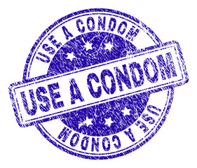 USE A CONDOM stamp seal imprint with distress texture. Designed with rounded rectangles and circles. Blue vector rubber print of USE A CONDOM label with retro texture.